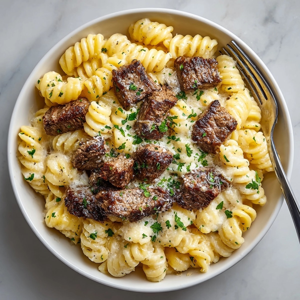 Cheesy Garlic Butter Steak Parmesan Rigatoni pasta glistening with buttery sauce, perfect for cozy nights.