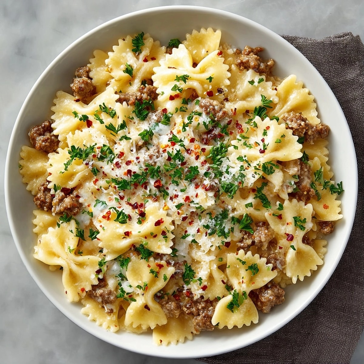 Creamy Beef and Bowtie Pasta with Alfredo Sauce in a skillet, ready for a comforting dinner.