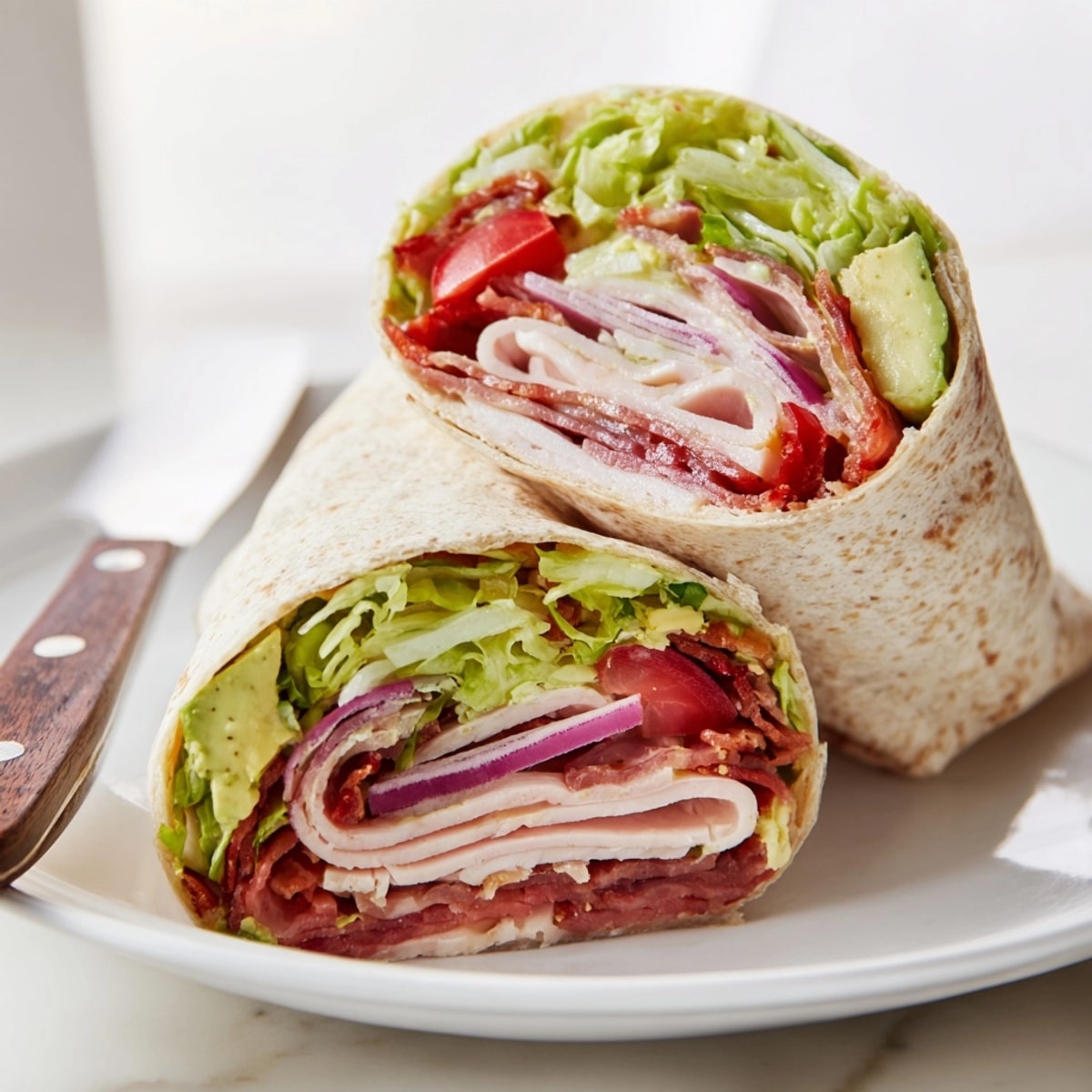 Stack of sliced Avocado and Turkey BLT Wraps reveals color layers and fresh ingredients.