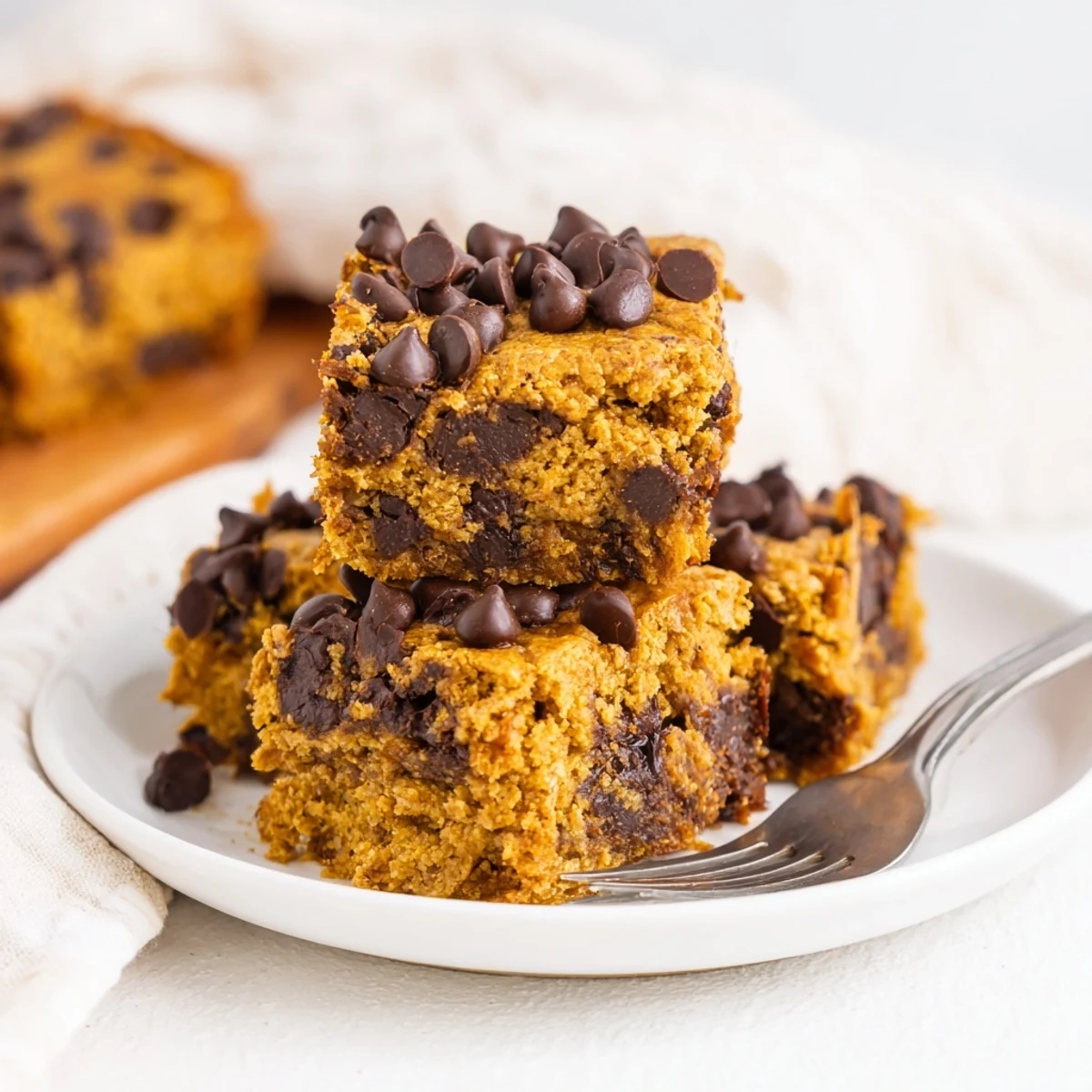 Moist gingerbread pumpkin chocolate chip muffin bars, perfect for fall gatherings.