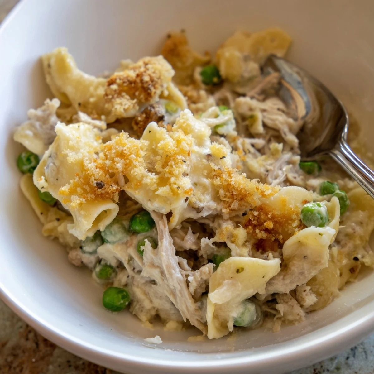 Creamy Low-Cost Tuna Noodle Casserole topped with crispy breadcrumbs and cheese.  