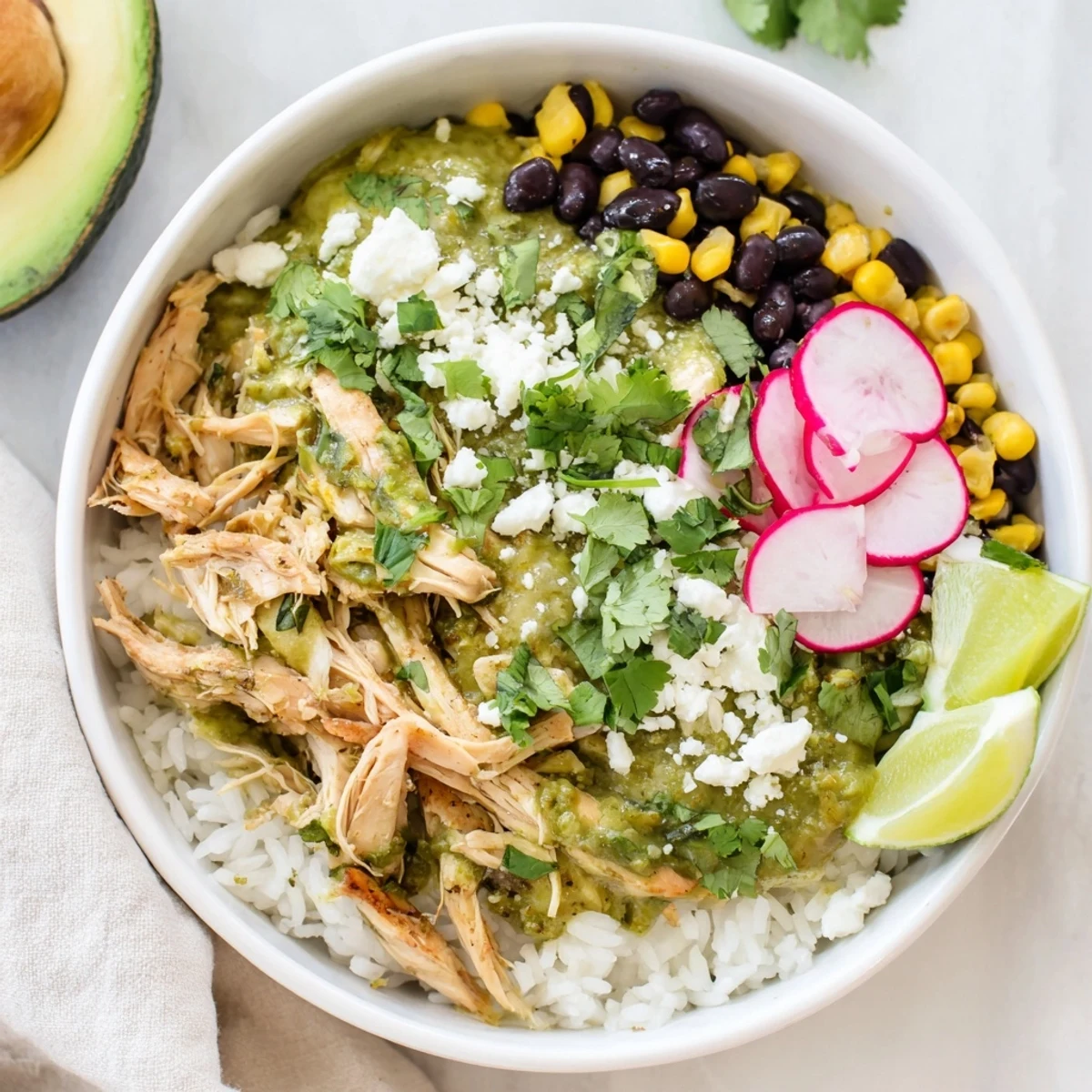Warm, zesty Green Enchiladas Rice Bowl garnished with radishes and lime wedges.  