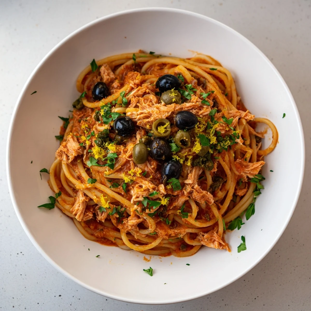 Golden spaghetti piled high with Pasta with Tuna, Olives & Capers, ready to enjoy.