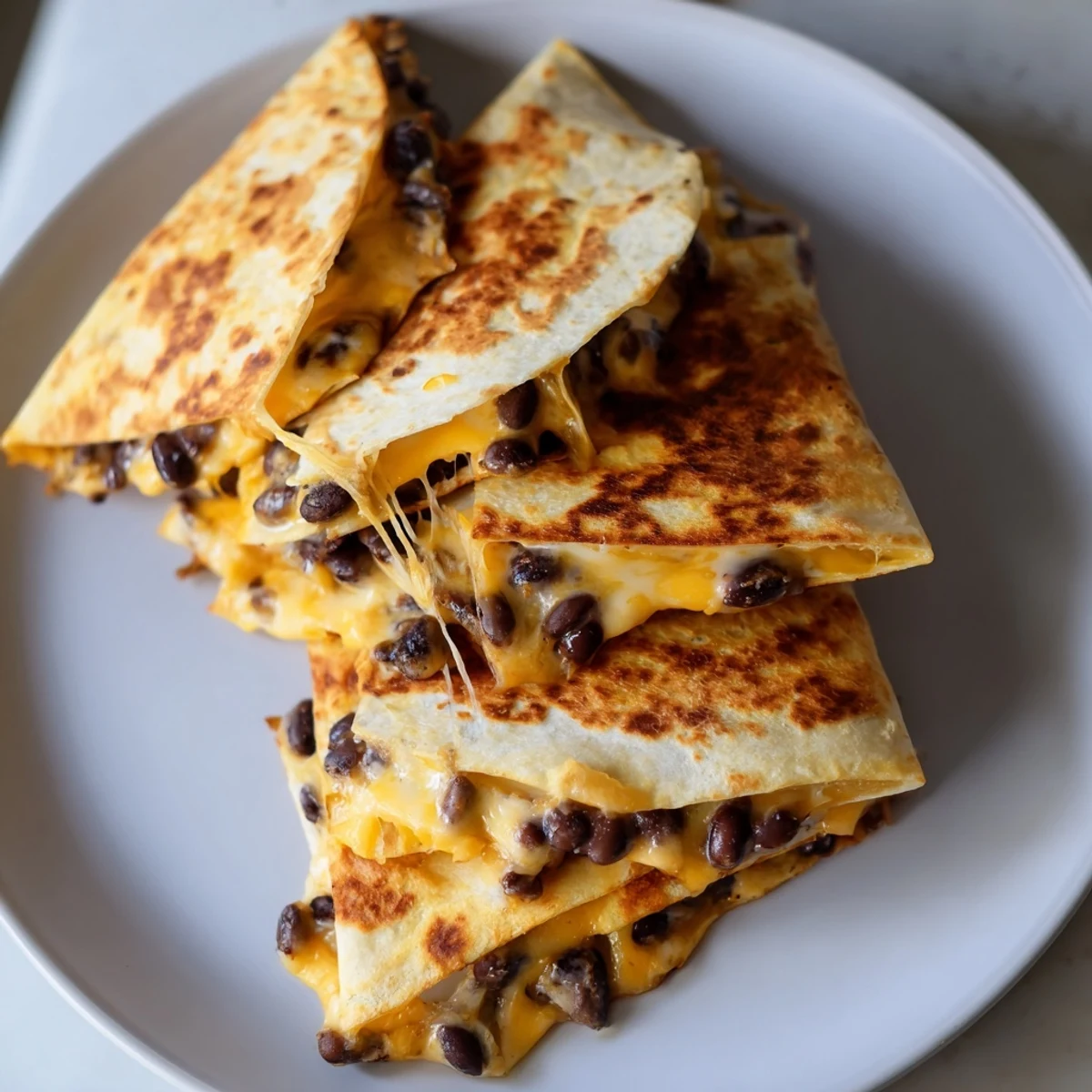 Golden, melted cheese oozing from a perfectly folded Bean & Cheese Quesadilla, ready to eat.