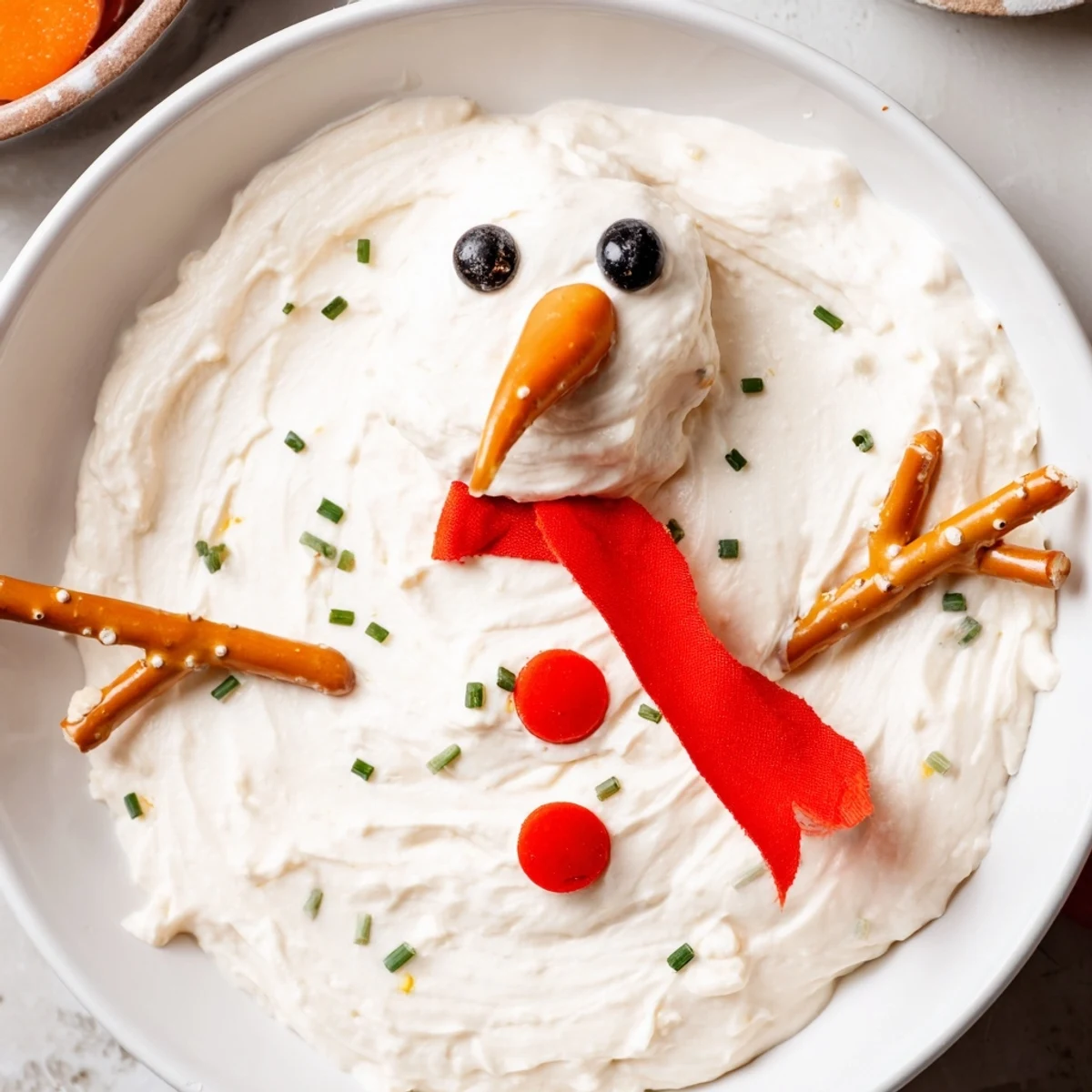 A freshly arranged Melted Snowman Dip, a creamy appetizer ready to be dipped into!