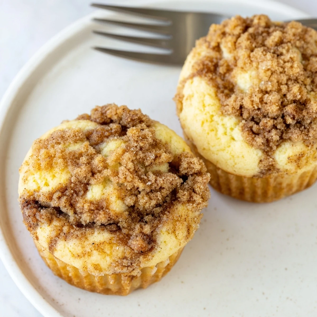 Fluffy Lightened Christmas Coffee Cake Muffins, baked golden brown with a sweet cinnamon swirl and streusel topping.