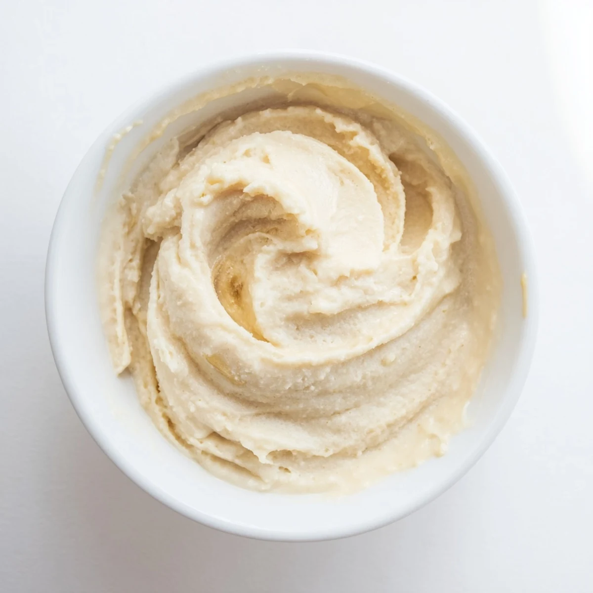 A rich, smooth 2-Ingredient Banana Ice Cream presented in a swirl, ready for a delicious bite.