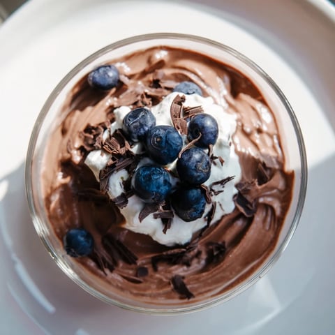 Silky avocado chocolate pudding topped with fresh berries, a decadent dairy-free dessert.