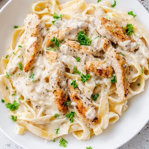 Creamy Skillet Chicken Alfredo with tender chicken and fettuccine, a comforting dinner.