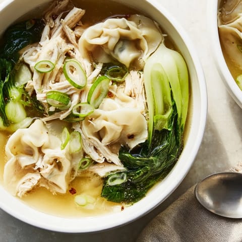 Comforting bowl of Simplified Wonton Soup topped with scallions and ginger slices.  
