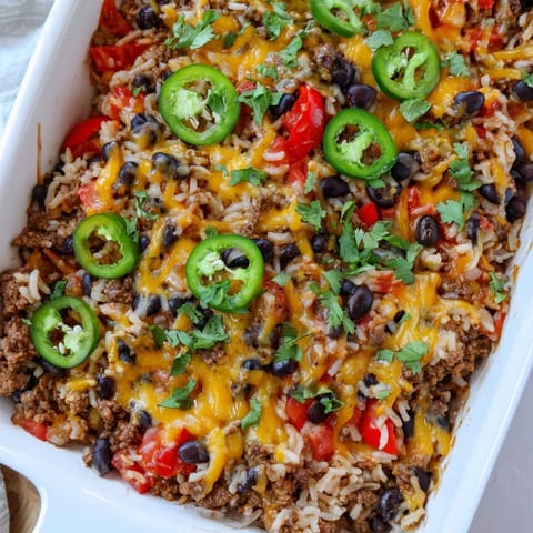A close-up shot of a steaming Tex-Mex Beef & Rice Casserole, loaded with colorful ingredients.