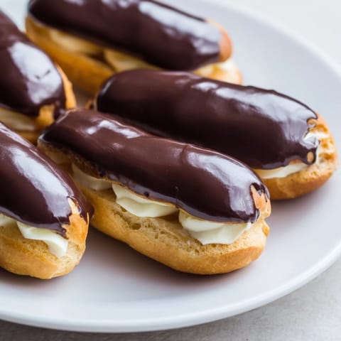 A platter of sweet bites: mini chocolate éclairs glistening with glaze offer a delightful French dessert experience.