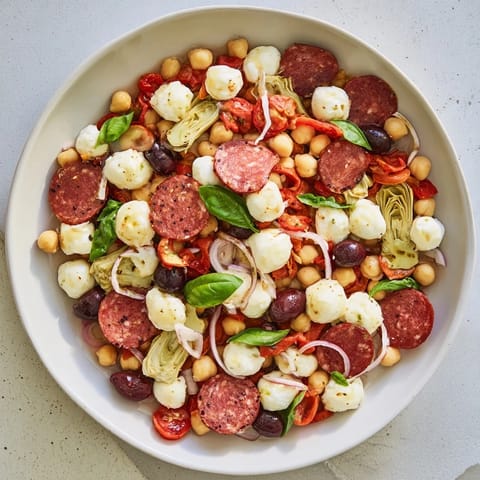 A close-up view of the Antipasto Chickpea Salad, showing plump chickpeas and colorful vegetables, ready to eat.
