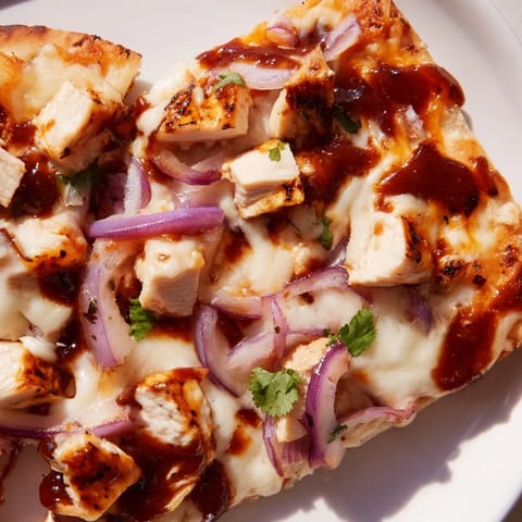 A close-up view of BBQ Chicken Flatbread slices showing gooey mozzarella, tangy BBQ sauce, and tender grilled chicken on a crispy golden crust.