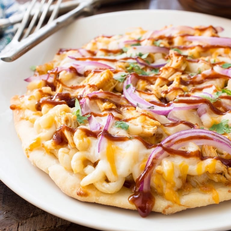 Slice of cheesy Mac and Cheese BBQ Chicken Pizza being lifted, appetizing and flavorful.