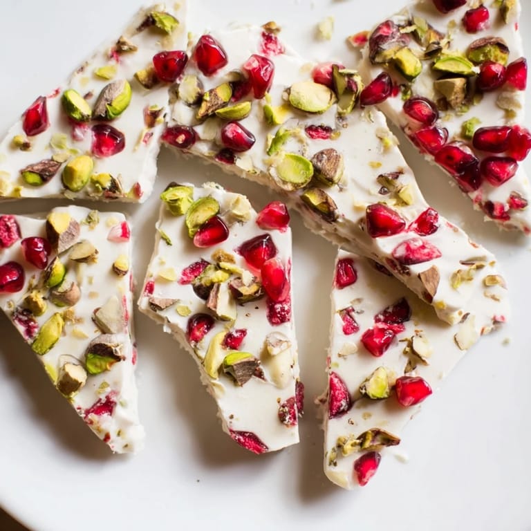 Colorful Frozen Yogurt Bark, a refreshing dessert, shows sweet pomegranate seeds and crunchy pistachios.