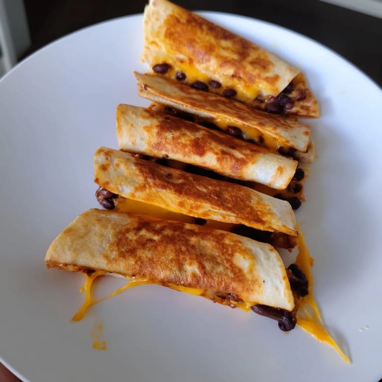 Crispy, golden-brown tortilla halves filled with savory beans and cheese: the easy Bean & Cheese Quesadilla.